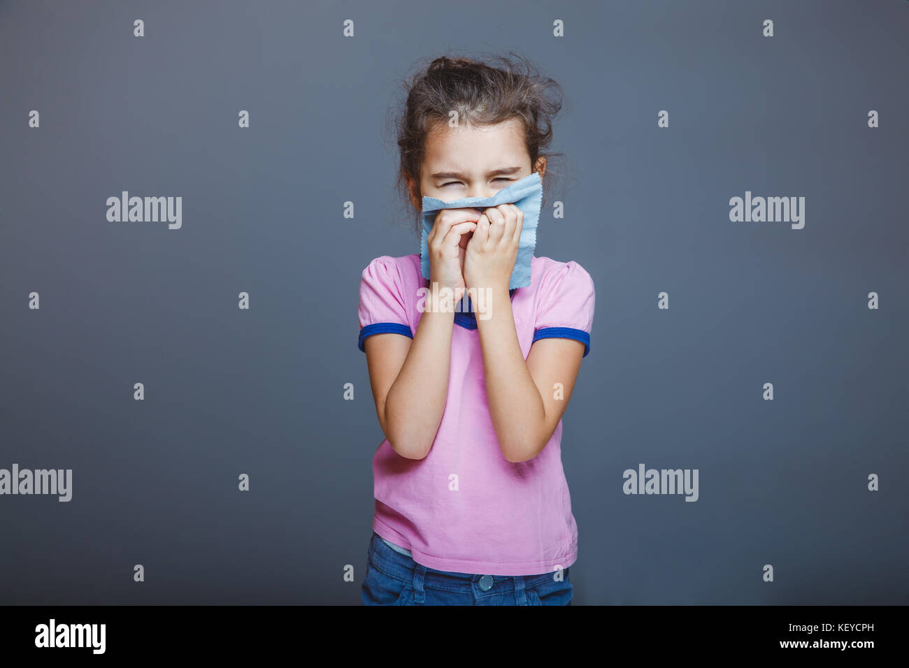 Fille avec un écoulement nasal enfoncé son mouchoir à son nez Banque D'Images