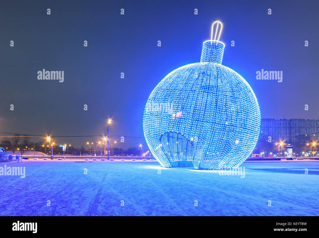 Boule de Noël bleu lumineux géant dans la rue avec de la neige Banque D'Images
