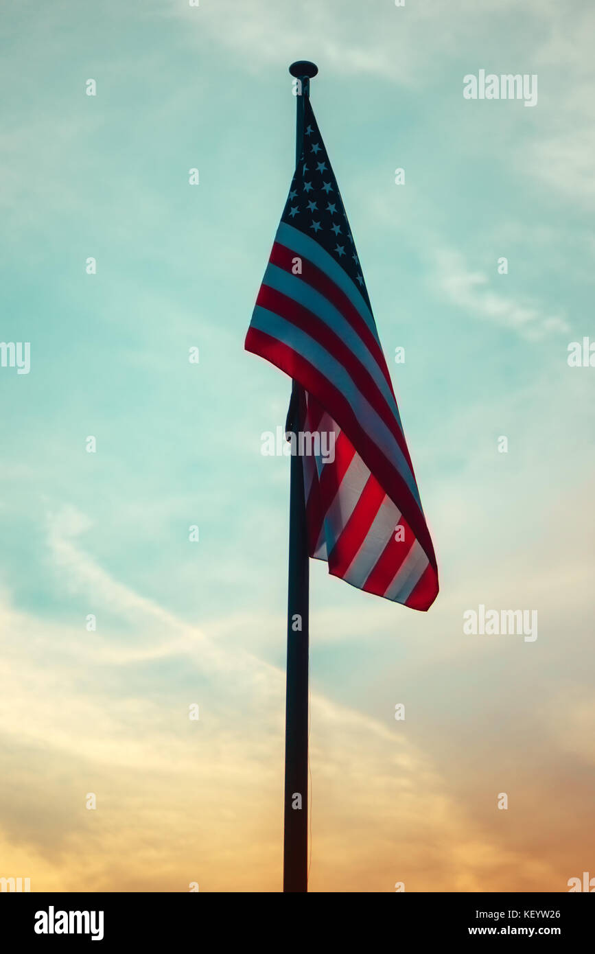 Usa drapeau sur poteau dans le coucher du soleil, american national bannière avec stars and stripes dans la soirée Banque D'Images
