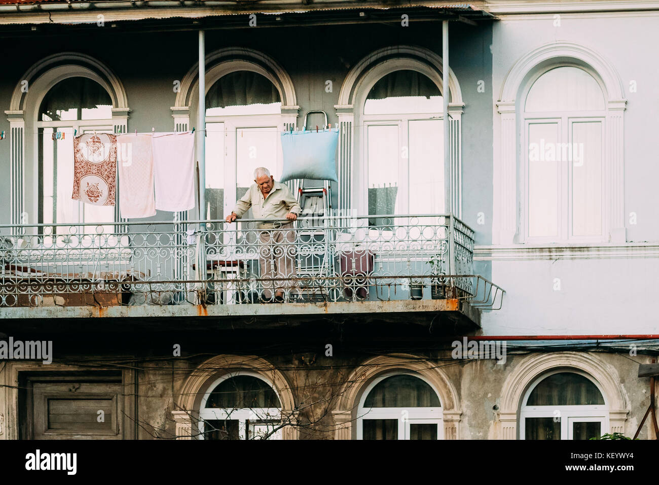 Batoumi, Adjara, Géorgie. Homme debout sur le balcon d'une vieille maison dans la vieille partie de Batoumi. Banque D'Images
