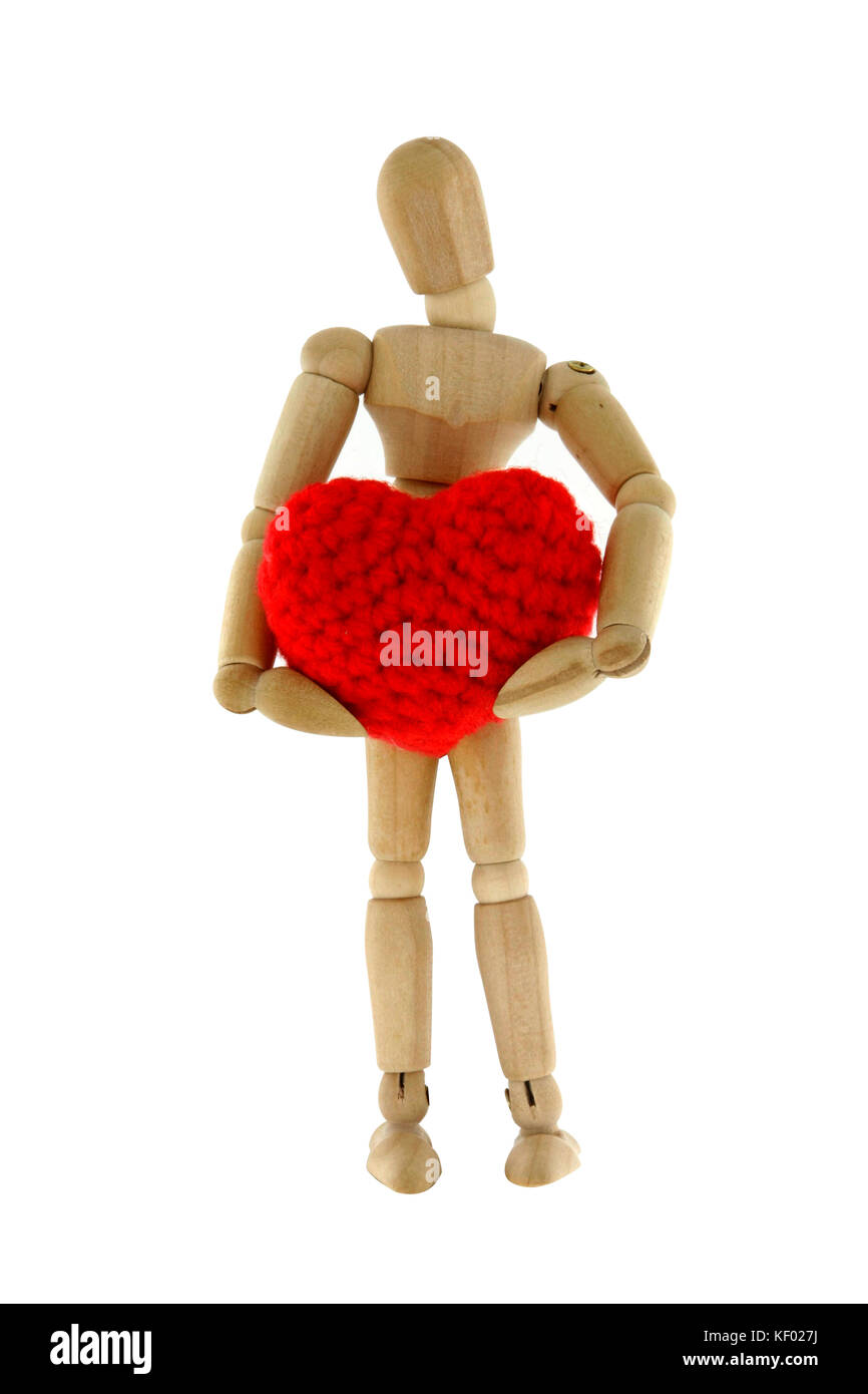 Mannequin en bois holding heart tricoté avec la laine, isolé sur fond blanc Banque D'Images