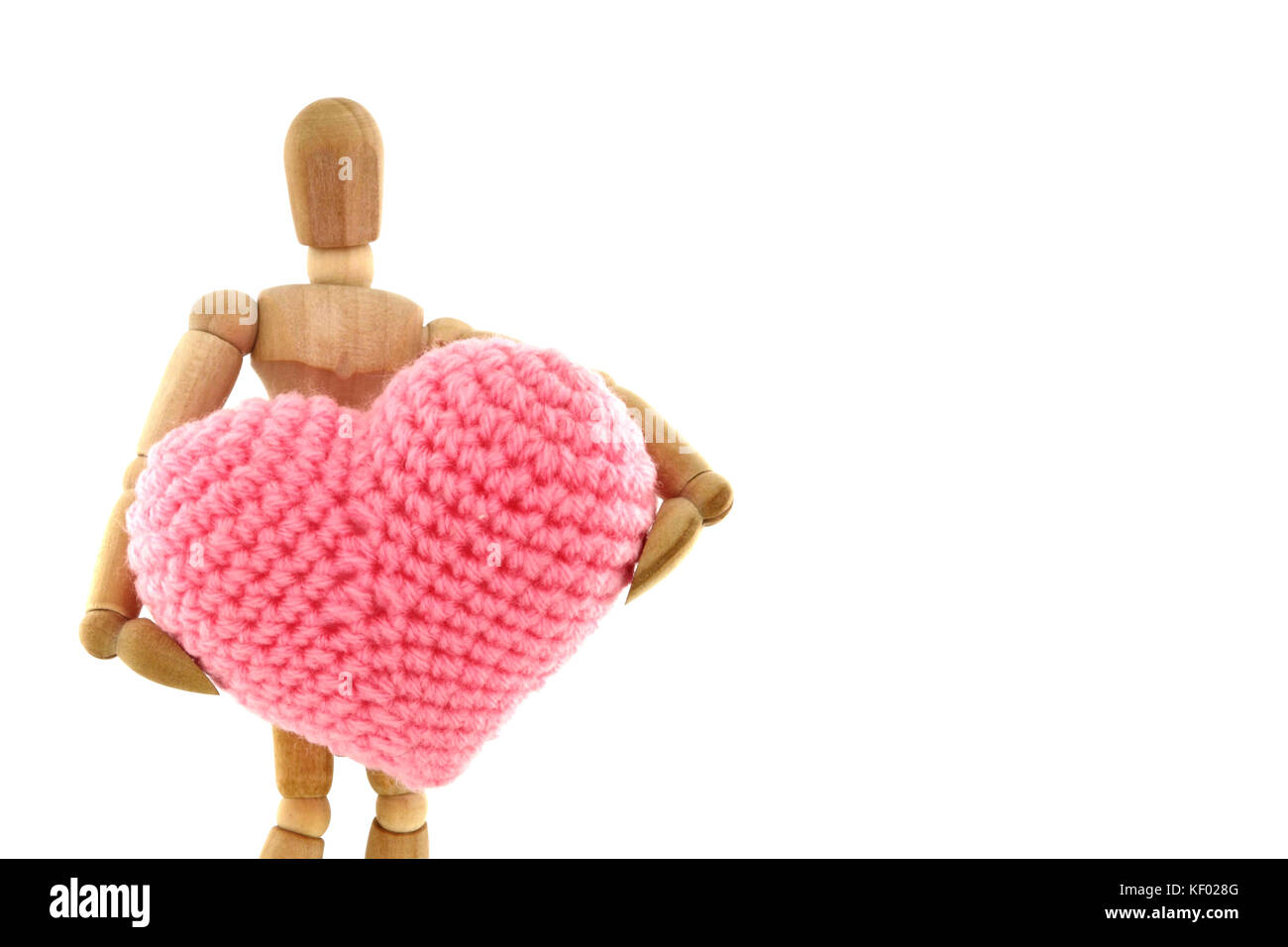 Mannequin en bois holding heart tricoté avec la laine, isolé sur fond blanc Banque D'Images