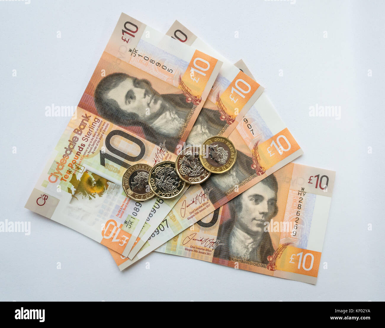 Polymère plastique Clydesdale Bank Scottish 10 livres £10 billets avec Robert Burns et hexagonaux une livre €1 pièces sur un arrière-plan uni, blanc Banque D'Images