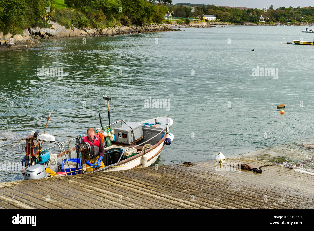 À propos de pêcheur à la tête sur les lieux de pêche de Schull slipway dans un petit bateau de pêche à Schull, West Cork, Irlande avec copie espace. Banque D'Images