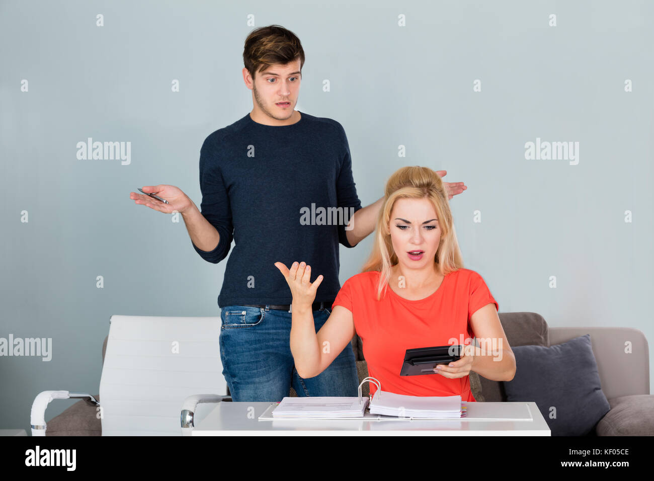 Un jeune couple choqué regarde les billets et le budget et pas d'argent laissé à la maison Banque D'Images