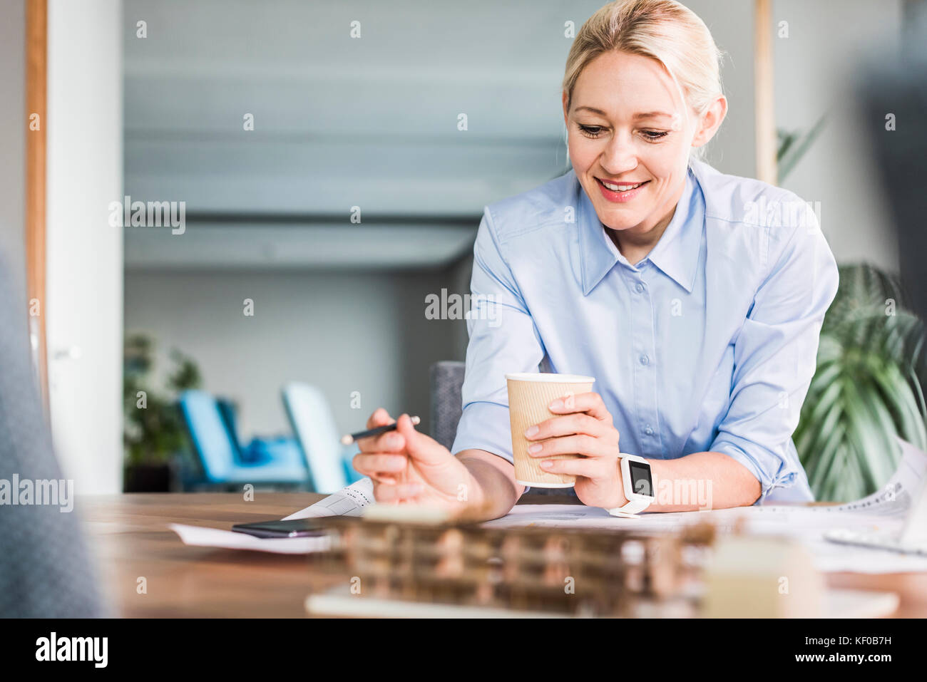 Smiling businesswoman working at desk in office Banque D'Images