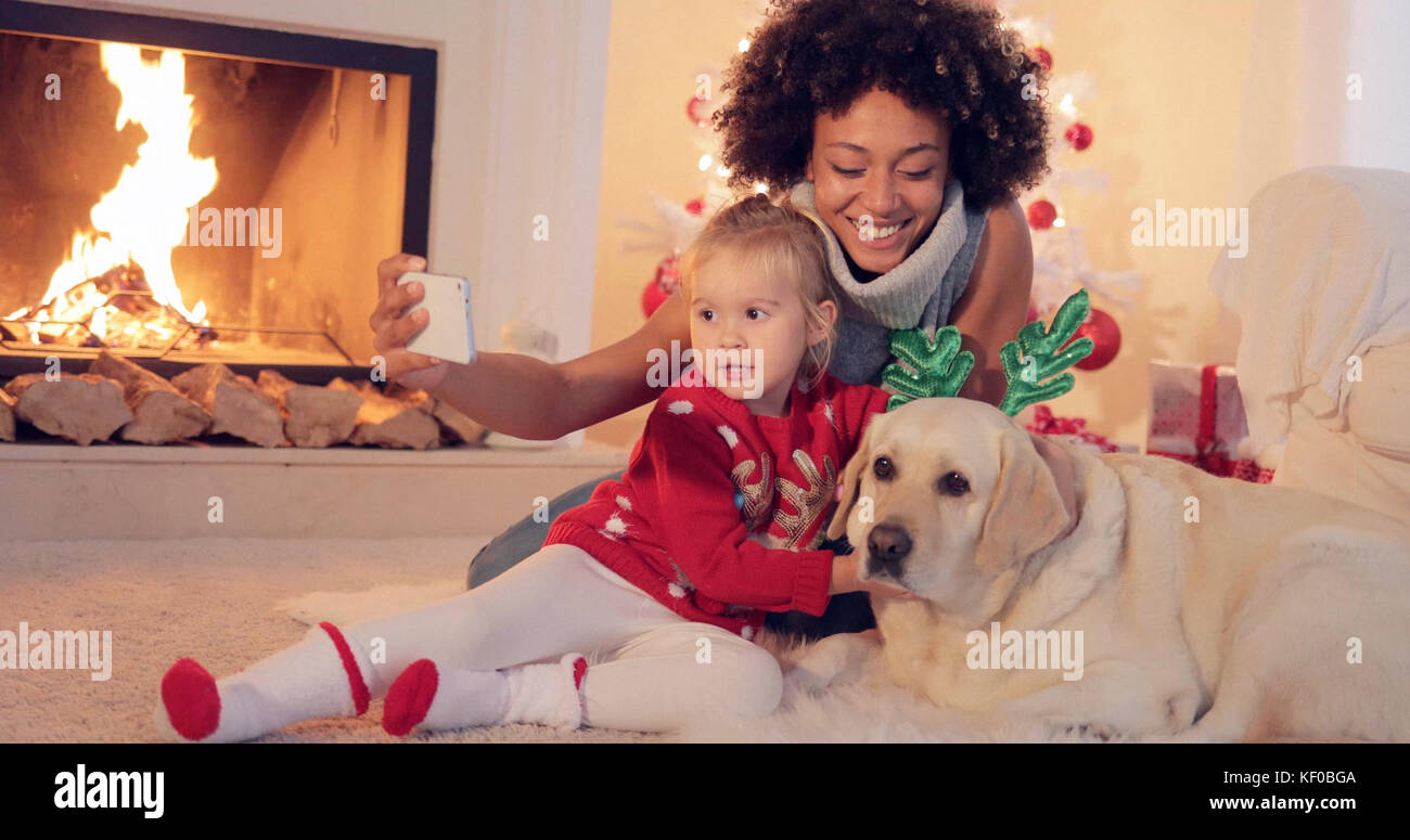Mixed Race family en tenant selfies noël Banque D'Images