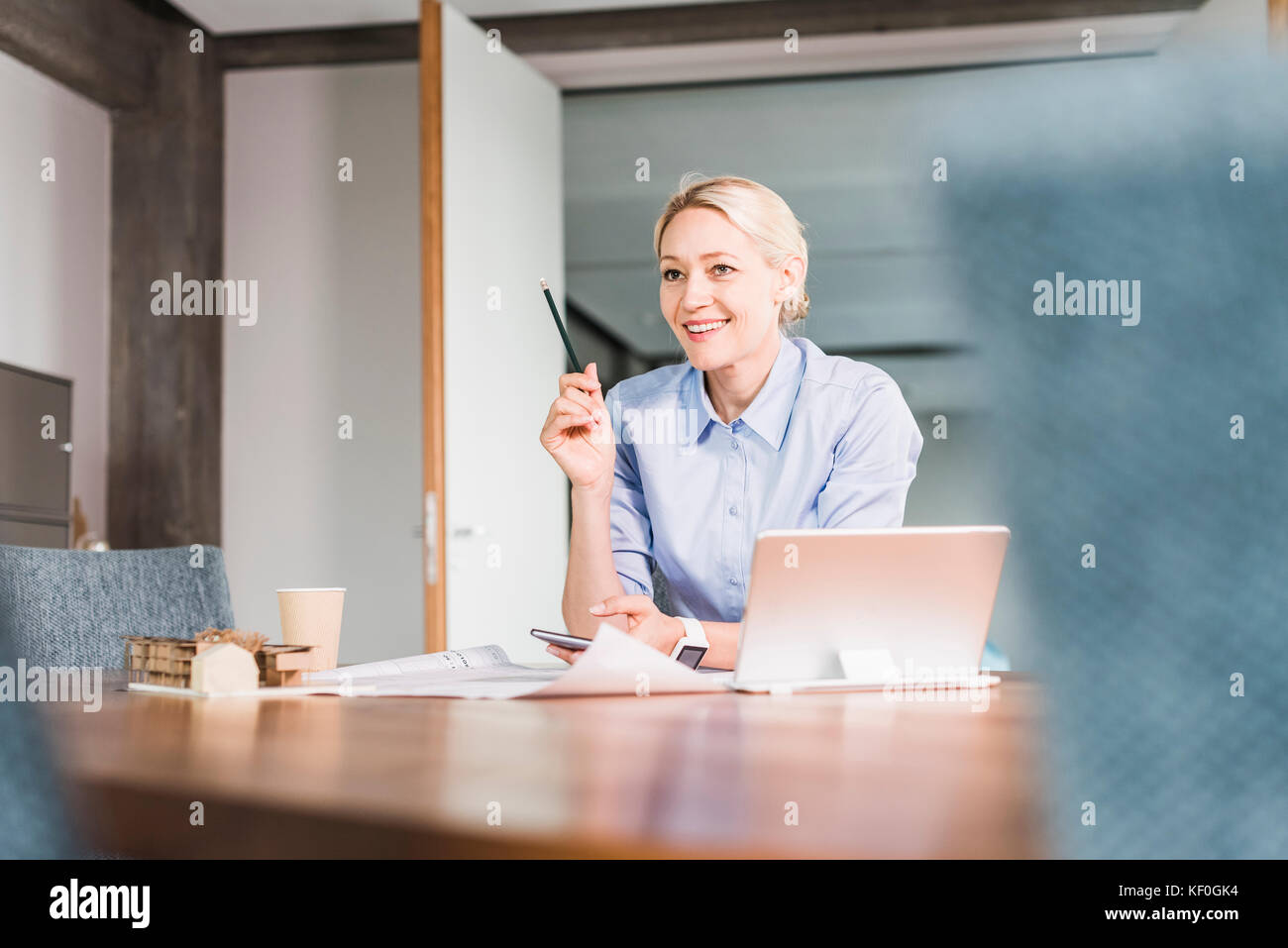 Smiling businesswoman working at desk in office Banque D'Images