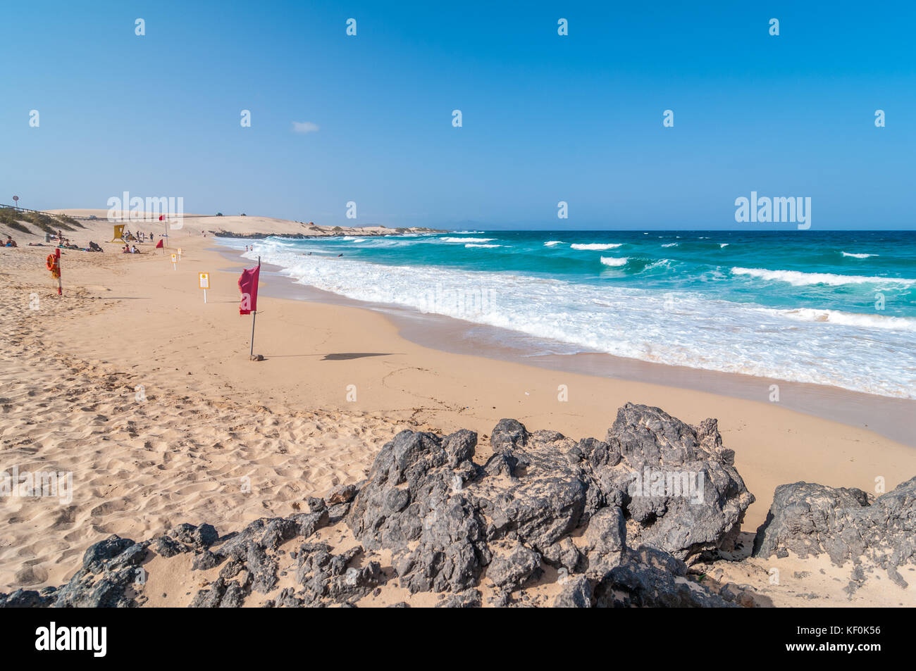 Vue de la plage avec quelques roches et des drapeaux rouges, Parque Natural de las Dunas de Corralejo, Fuerteventura, Îles Canaries, Espagne Banque D'Images