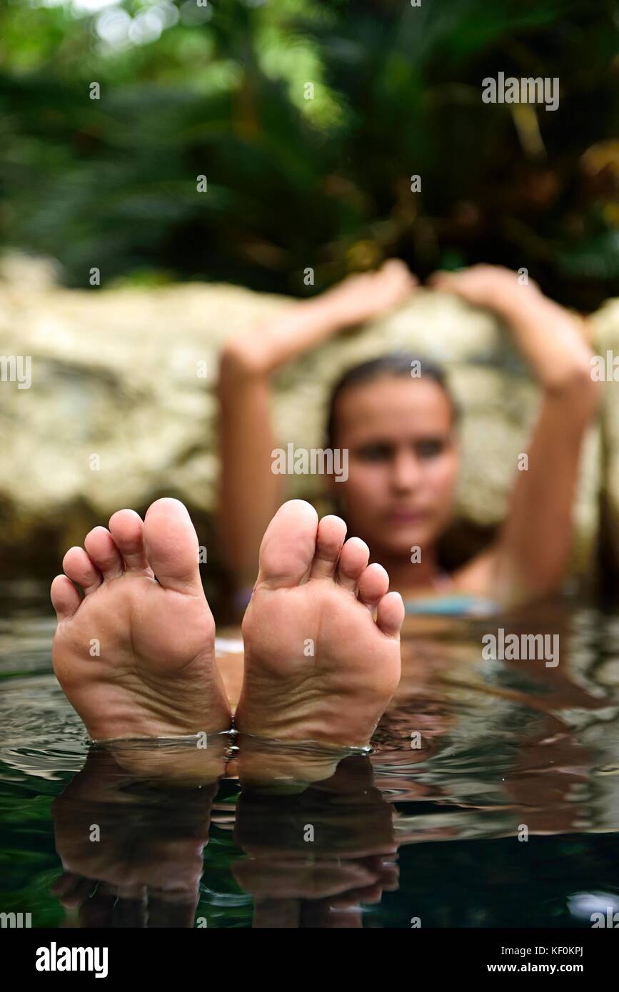 Pieds de jeune femme se détendre dans la piscine naturelle Banque D'Images