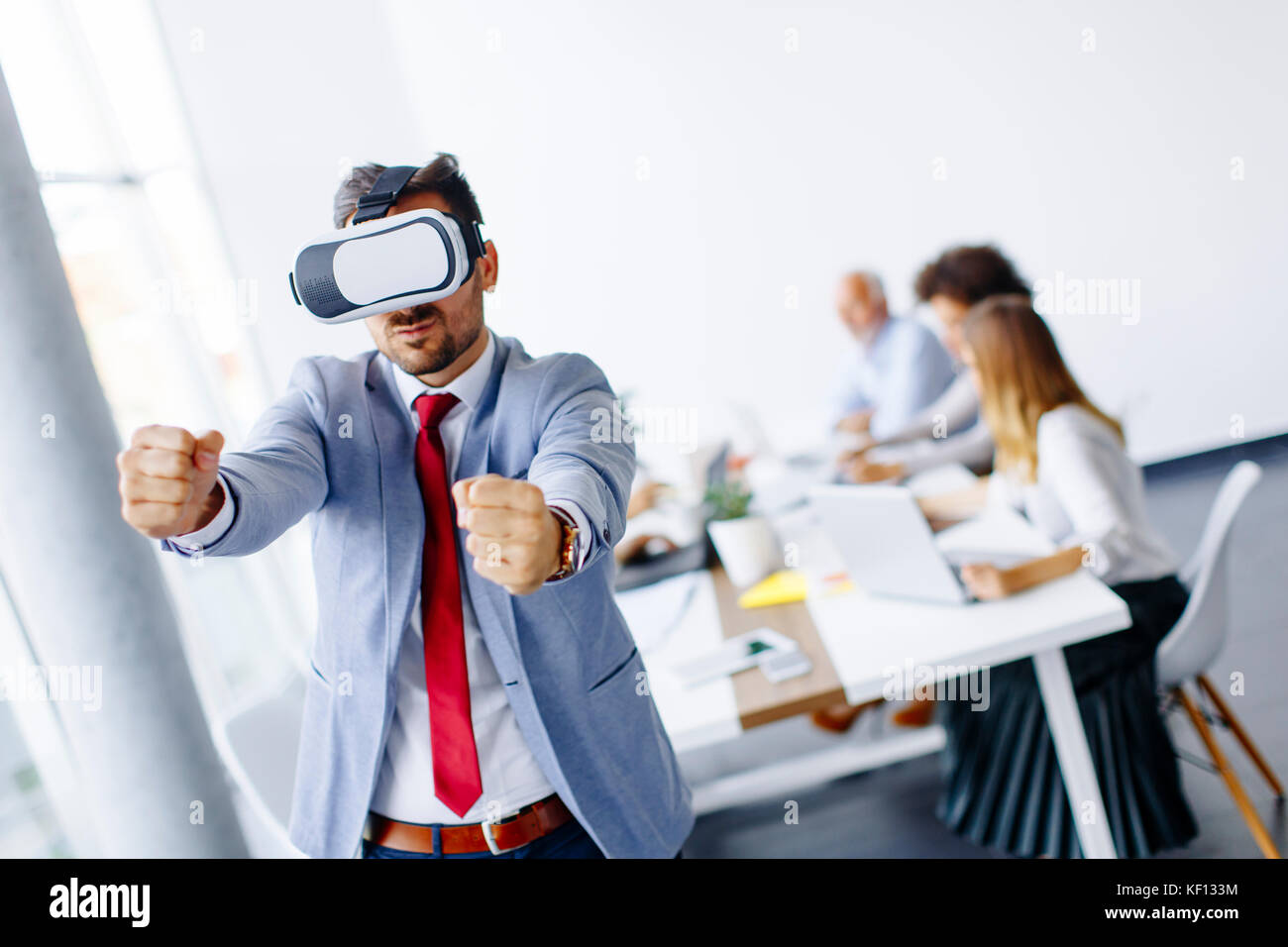 Homme d'affaires moderne avec un casque de réalité virtuelle dans le bureau s'amusant Banque D'Images