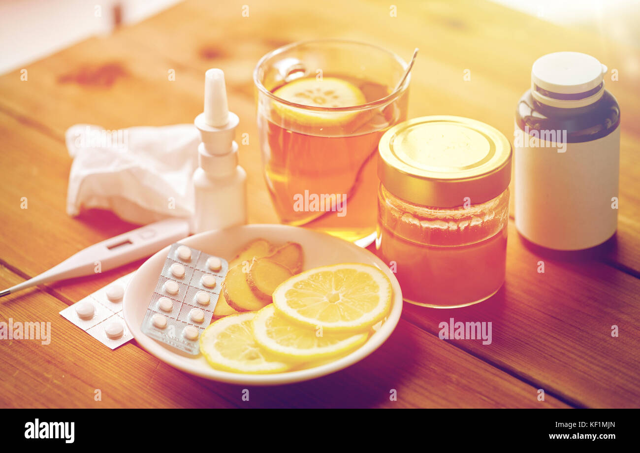 La drogue, thermomètre, le miel et une tasse de thé sur bois Banque D'Images