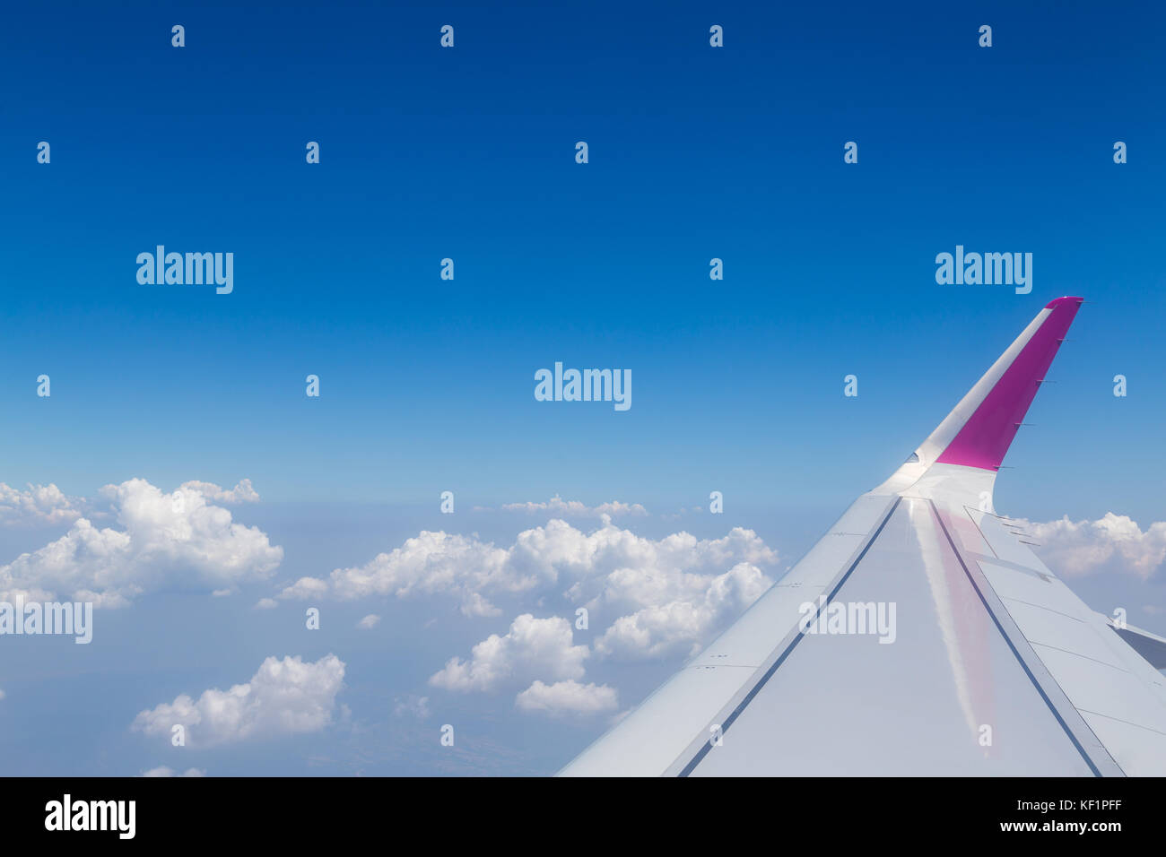 Horizon bleu avec des nuages, vue aérienne de l'avion, avec l'aile visible Banque D'Images