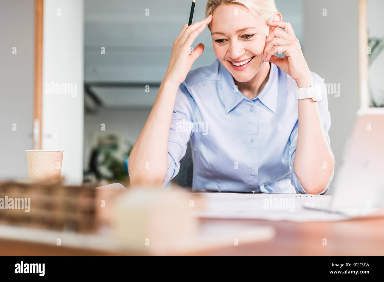 Smiling businesswoman working at desk in office Banque D'Images