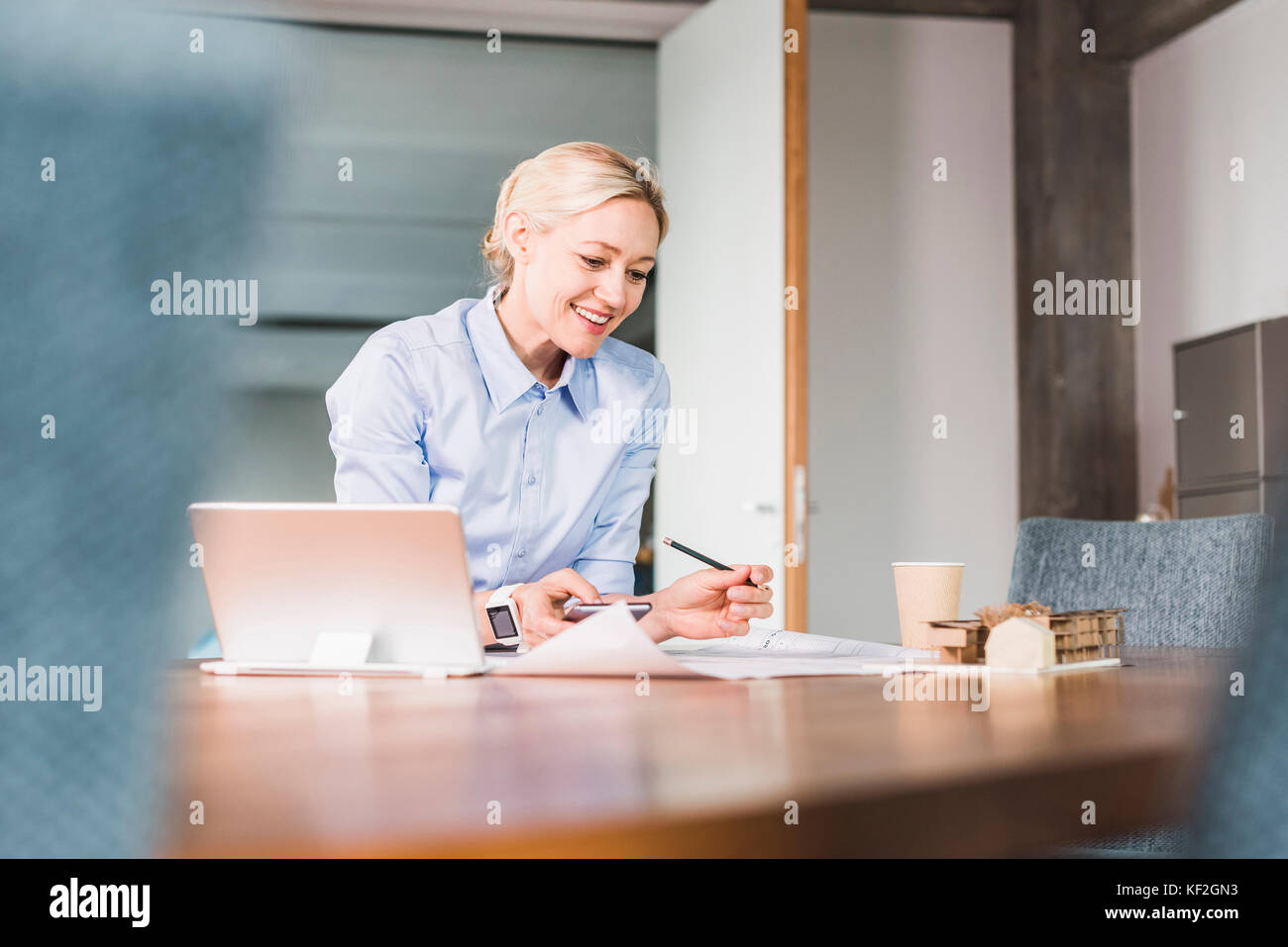 Smiling businesswoman working at desk in office Banque D'Images