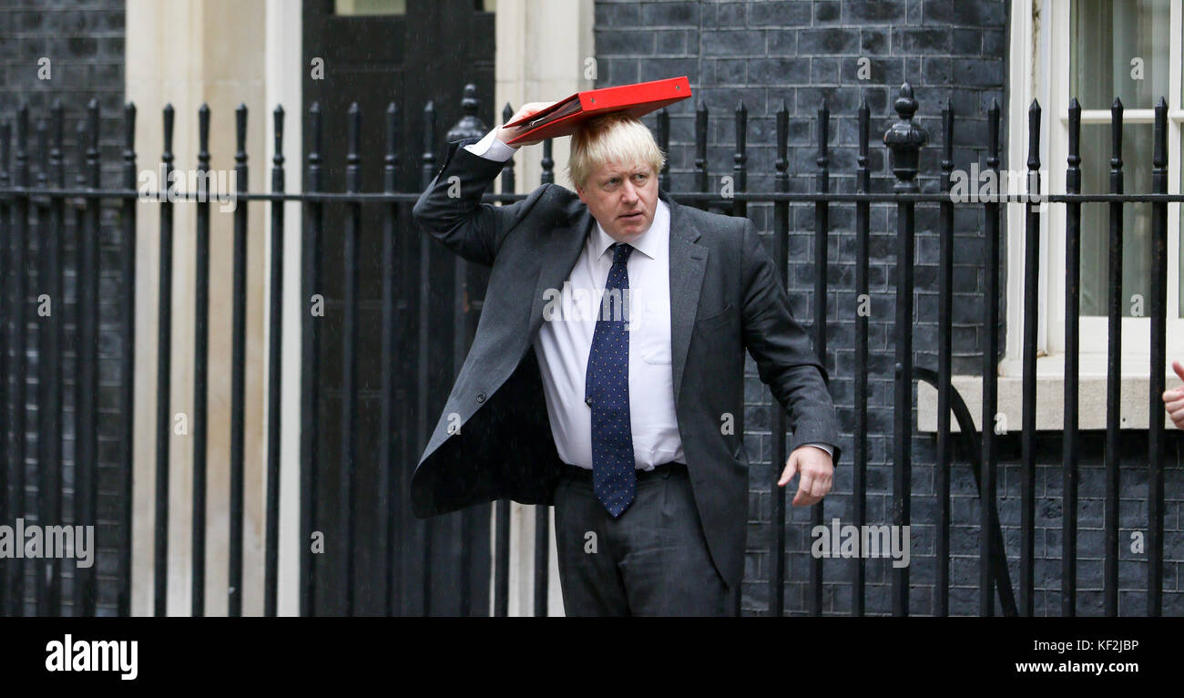 Secrétaire des affaires étrangères, Boris Johnson, en laissant 10 Downing street aujourd'hui couvrant la tête de la pluie avec son dossier rouge. Banque D'Images