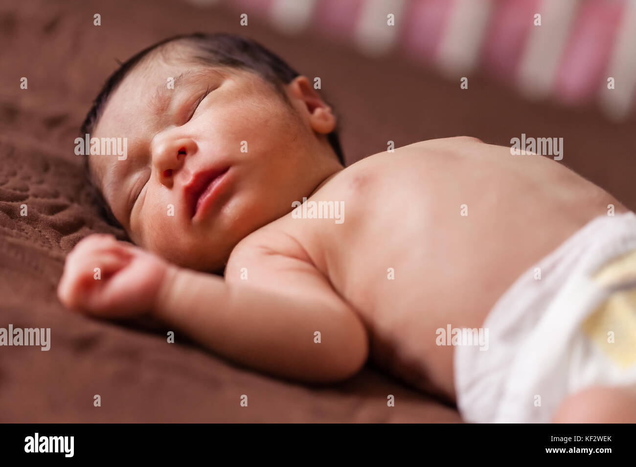 Une mignonne de deux semaines nouveau-né bébé fille sans vêtements, nu ou nu en utilisant un couches ou de couches, dormir paisiblement dans le lit / nouveau-né bébé fille sommeil Banque D'Images