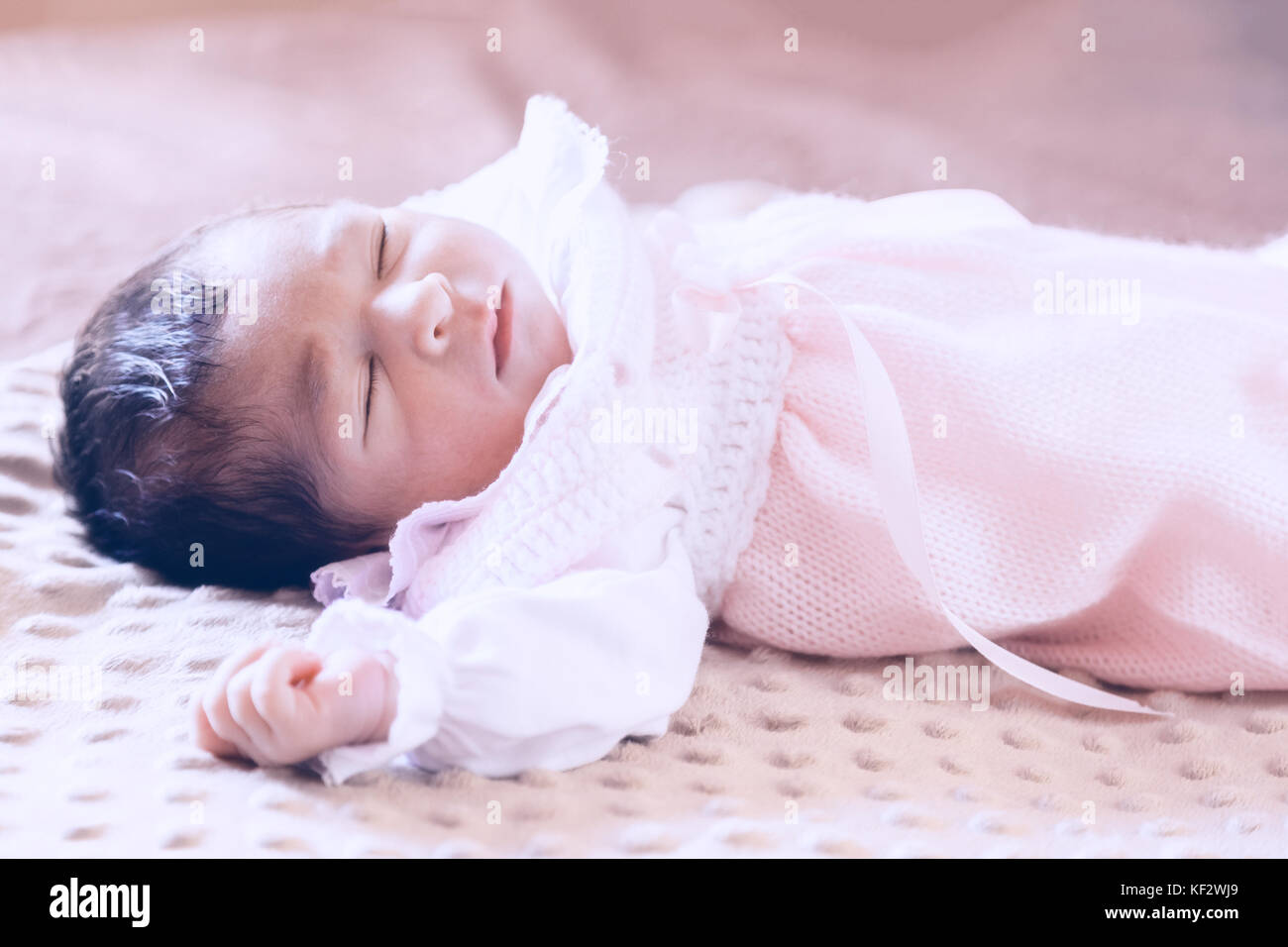 Deux semaines au nouveau-né cute baby girl rose doux vêtements tricotés, dormir paisiblement dans son lit / Naissance bebe Fille Dormir dormir couchette enfant Banque D'Images