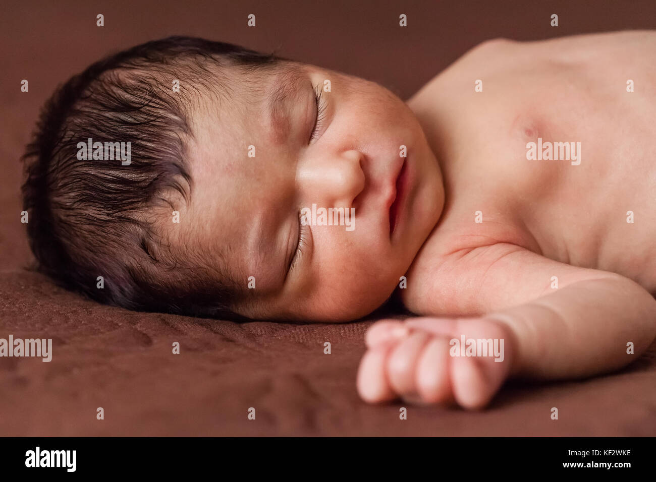 Gros plan portrait d'un mignon deux semaines nouveau-né bébé fille sans vêtements, nu ou nu, dormir paisiblement dans le lit / nouveau-né bébé fille dormir Banque D'Images