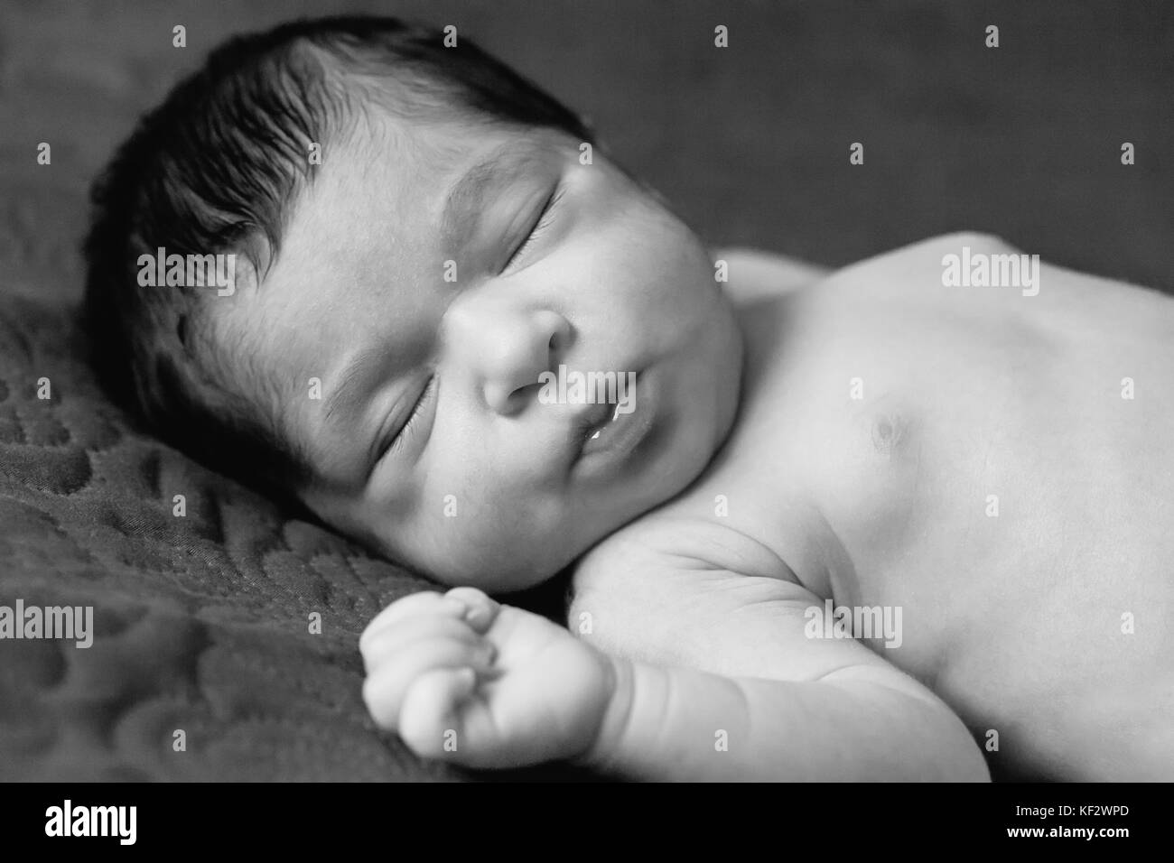 Gros plan portrait d'un mignon deux semaines nouveau-né bébé fille sans vêtements, nu ou nu, dormir paisiblement dans le lit / nouveau-né bébé fille dormir Banque D'Images