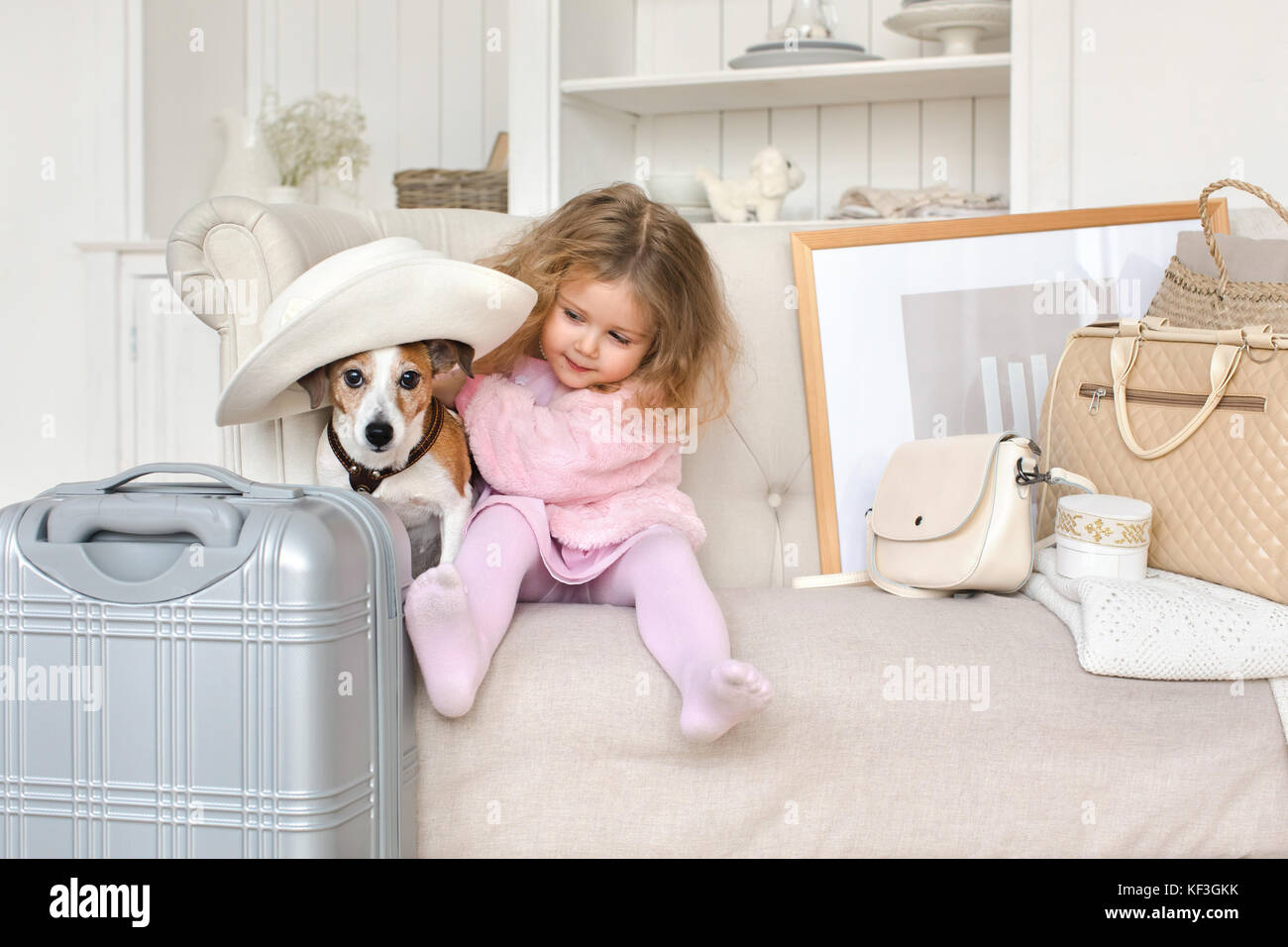 Une petite fille avec des valises et un chien à l'intérieur Banque D'Images
