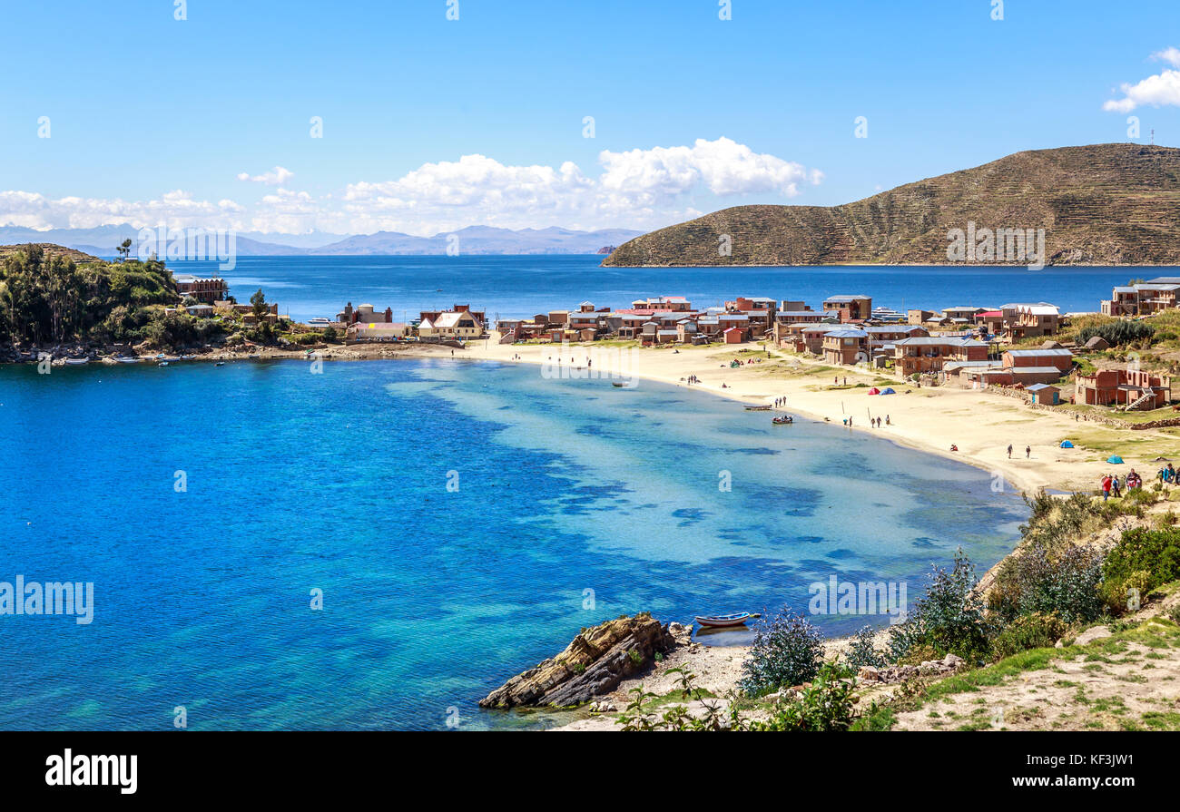 L'eau bleue et de la côte du lac Titicaca, les bateaux, les gens à pied et boliviens au village incas île du soleil, la Bolivie, l'Amérique du Sud Banque D'Images