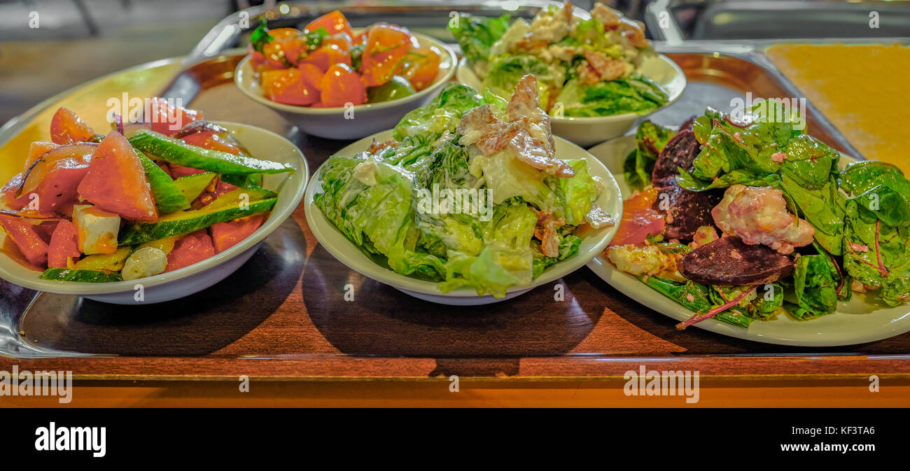 Des plaques différentes salades sur un plateau en bois à la choix de salades à la cantine. Banque D'Images