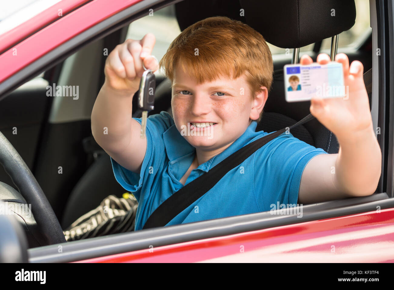 Heureux l'enfant assis à l'intérieur montrant Voiture Permis de conduire et clés Banque D'Images