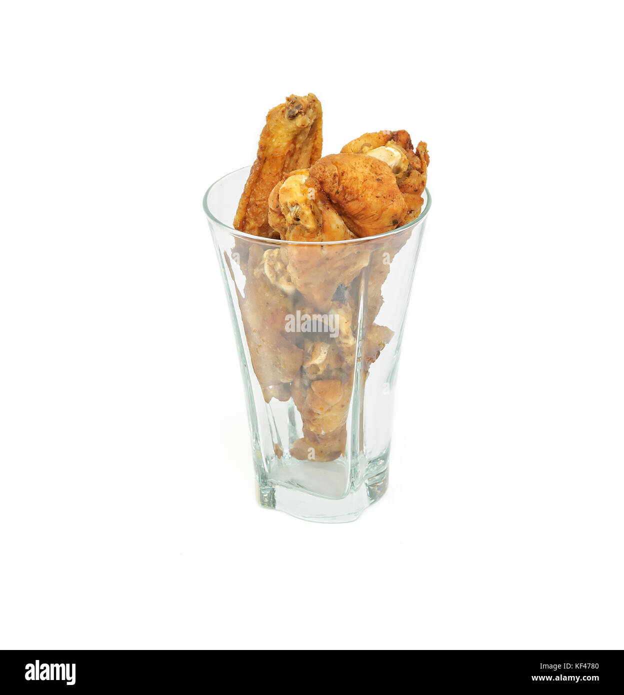 Pilons de poulet frit et les ailes dans un verre isolé sur fond blanc Banque D'Images