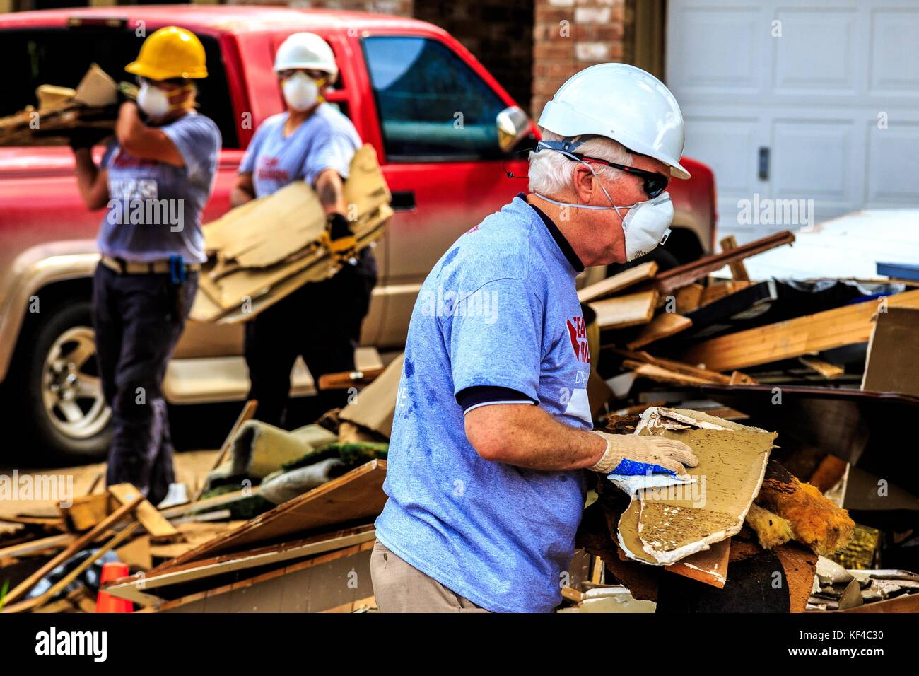 John carter, membre du Congrès américain, aide des bénévoles à ramasser des débris dans une maison détruite par l'ouragan Harvey le 21 septembre 2017 à Friendswood, au Texas. Banque D'Images