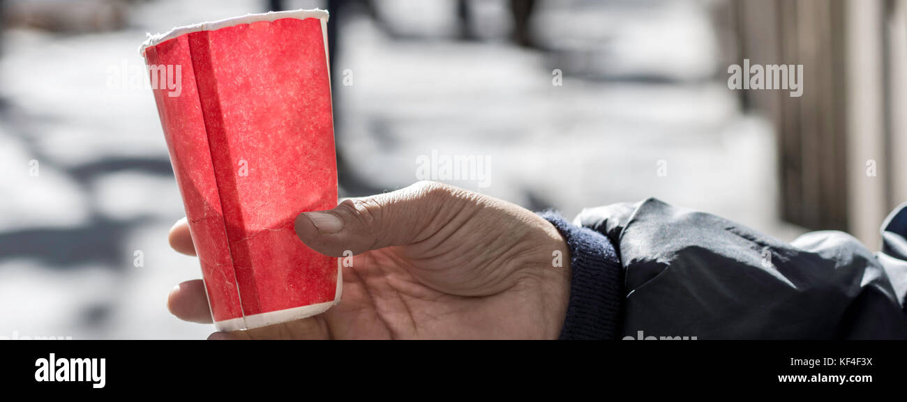 Pauvre homme mendier de l'argent sur la rue Close Up. Mendiant sale Hand Holding Paper Cup Banque D'Images