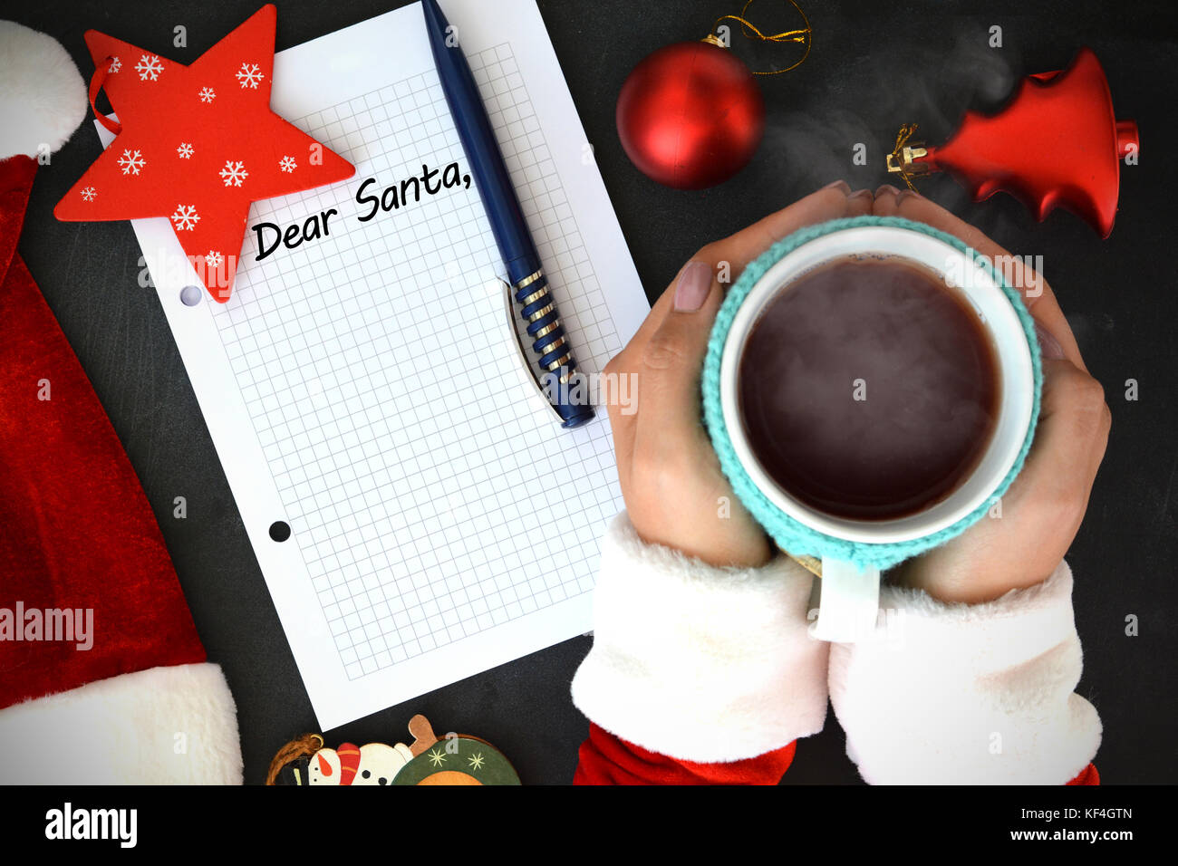 Cher Père Noël, texte sur livre de maths avec femme main tenant une tasse de thé chaud près de Santa's hat et accessoires de Noël du père noël - le temps de la liste de souhaits conce Banque D'Images