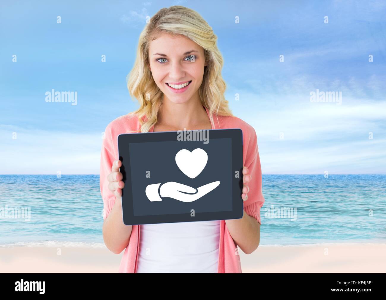 Digital composite of Woman holding tablet donnant la main avec icône de cœur Banque D'Images