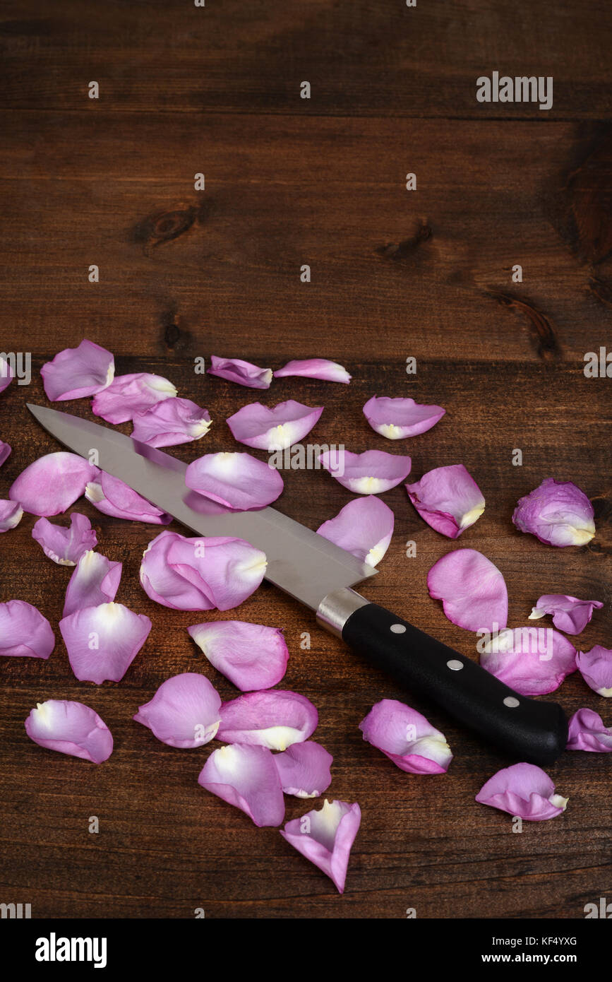 Couteau de boucher avec des pétales de rose Banque D'Images