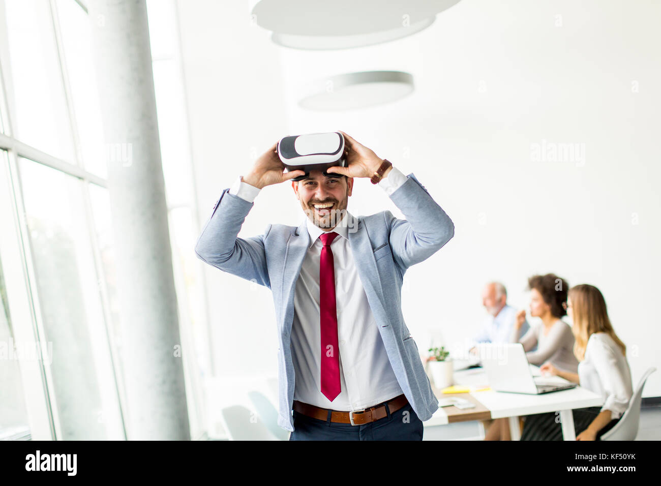 Homme d'affaires moderne avec un casque de réalité virtuelle dans le bureau s'amusant Banque D'Images
