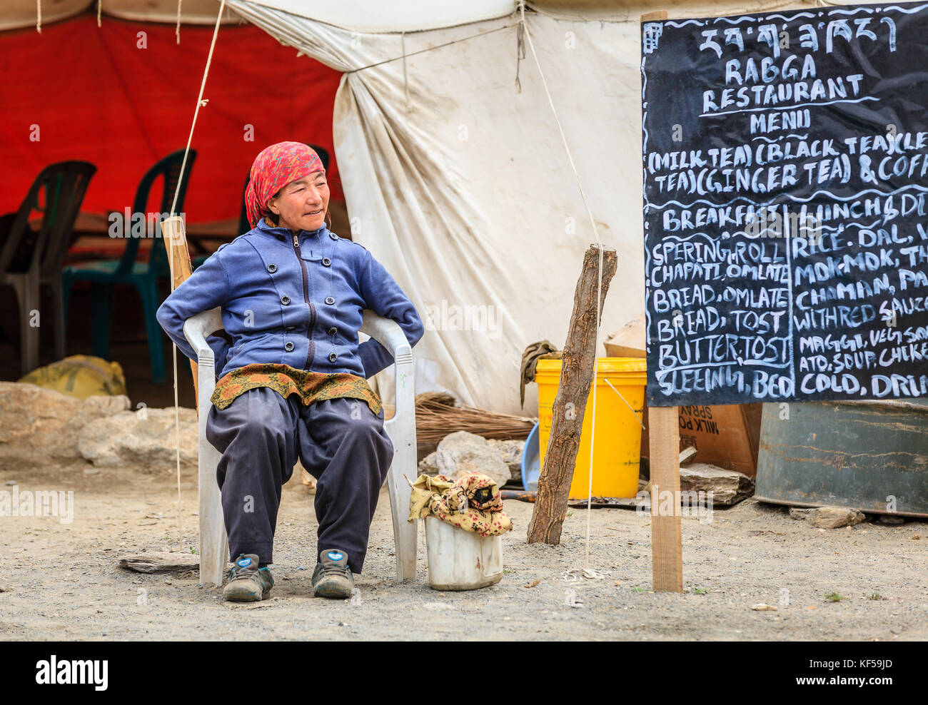 Le Ladakh, Inde, le 16 juillet 2016 : femme assise locale par le menu Se connecter d'une cantine en bordure de plateau changthang, Ladakh, Cachemire, Inde Banque D'Images