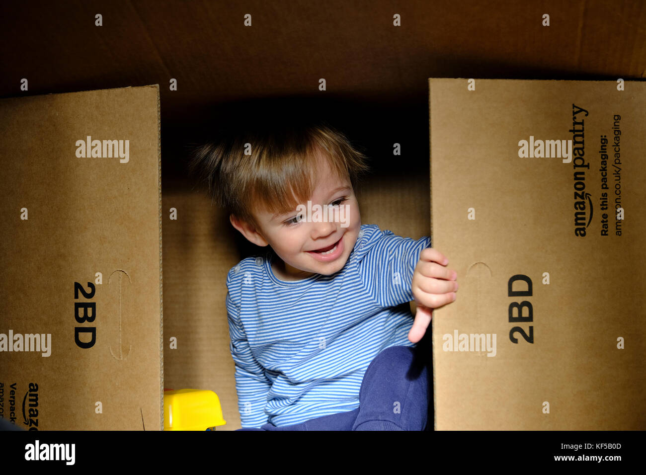 Un bébé garçon jouant à l'intérieur d'une grande boîte en carton boîte de  livraison d'amazon Photo Stock - Alamy