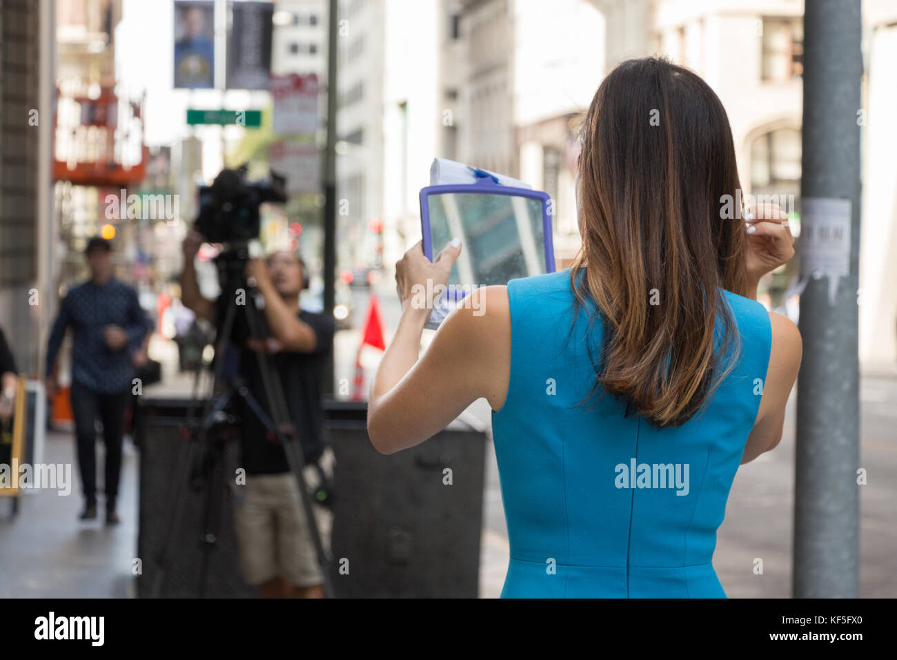 San Francisco, USA - Septembre 13th, 2017 : une femme journaliste de télévision est à son miroir avant diffusion à un coin de la ville de San Francisco. Banque D'Images