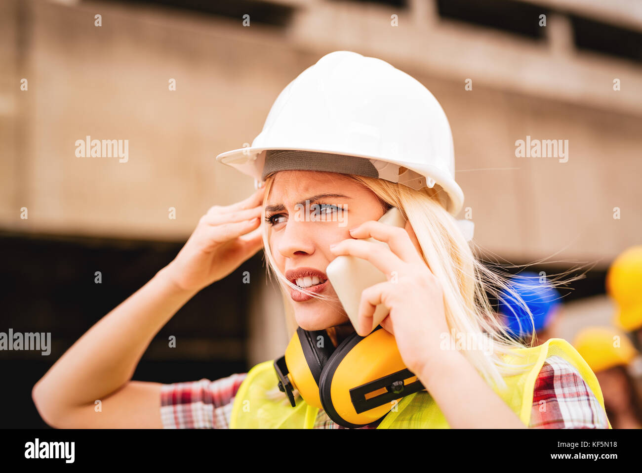 Les jeunes femmes à l'aide d'architecte construction inquiète téléphone devant des édifices endommagés dans la catastrophe. close up. Banque D'Images