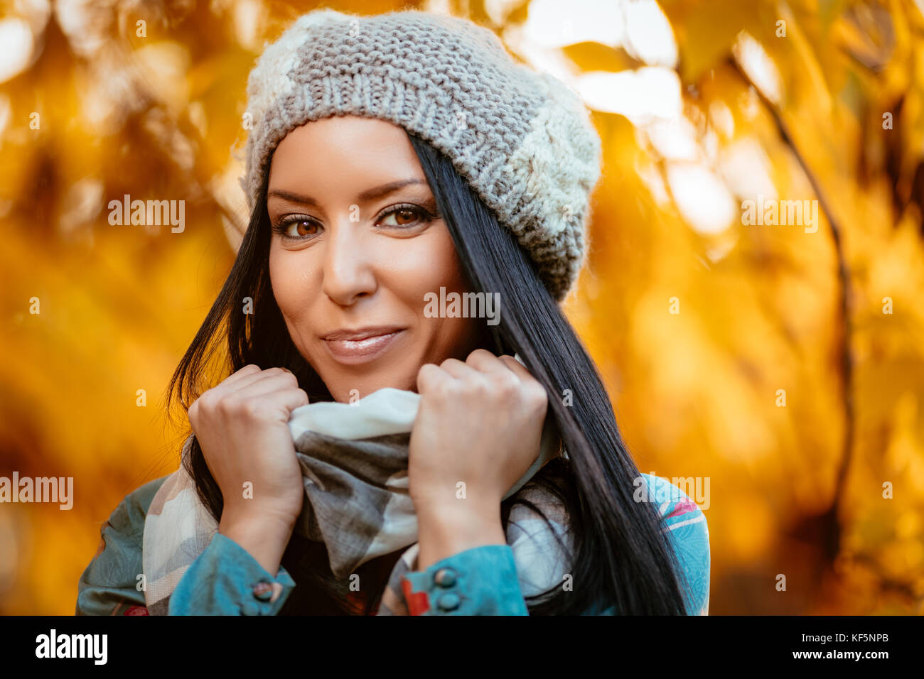 Portrait of young beautiful smiling girl positive écharpe de réglage en automne. looking at camera. Banque D'Images