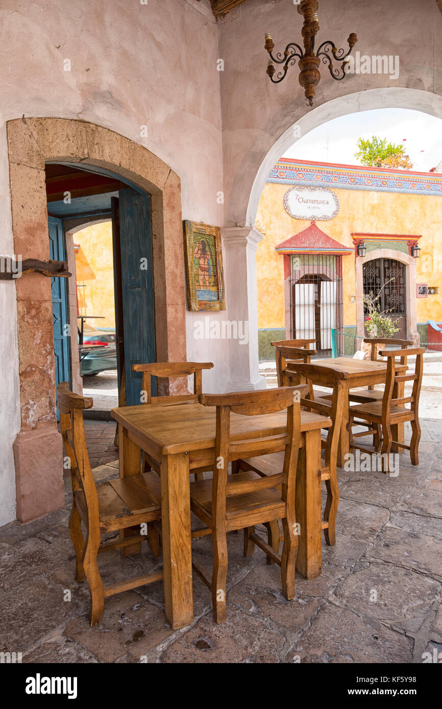 1 mars 2016 Bernal, Mexique : chaises de restaurant à l'ombre de colonial arch dans le hstoric centre de la ville touristique populaire Banque D'Images