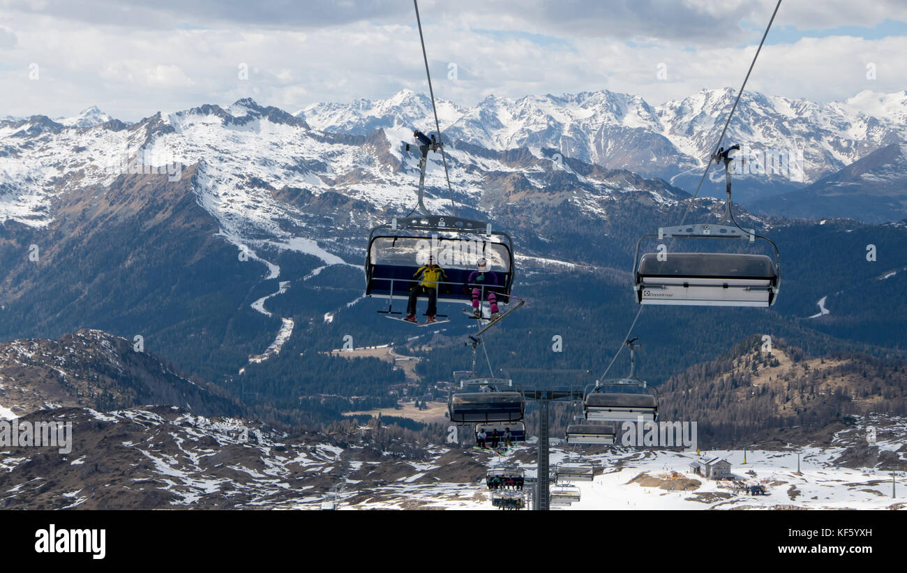 Madonna di campliglio, italie - apirl : 8 skieurs et planchistes voyageant par le télésiège de ski populaire Banque D'Images
