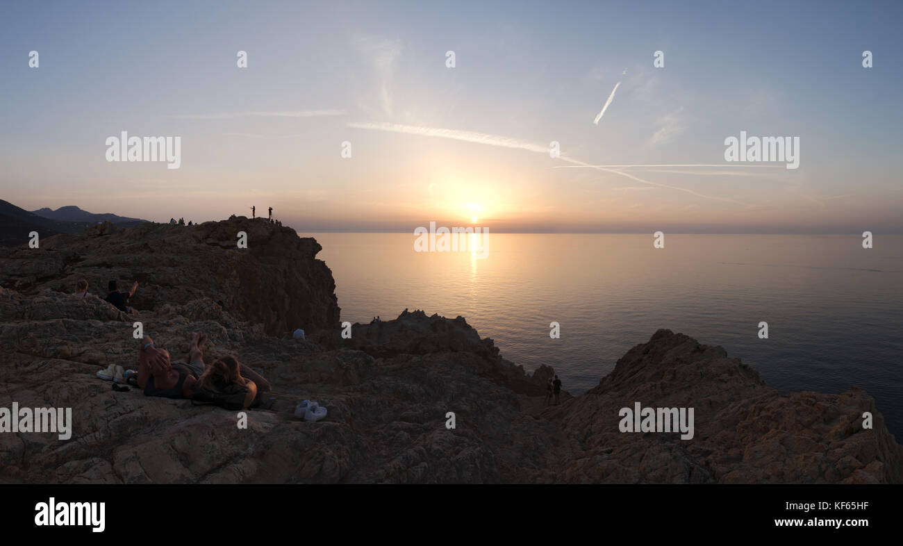 Corse : les personnes à la recherche au coucher du soleil sur la mer méditerranée depuis le haut de l'ile de la pietra (pierre), promontoire de l'Île-rousse (l'île rouge) Banque D'Images