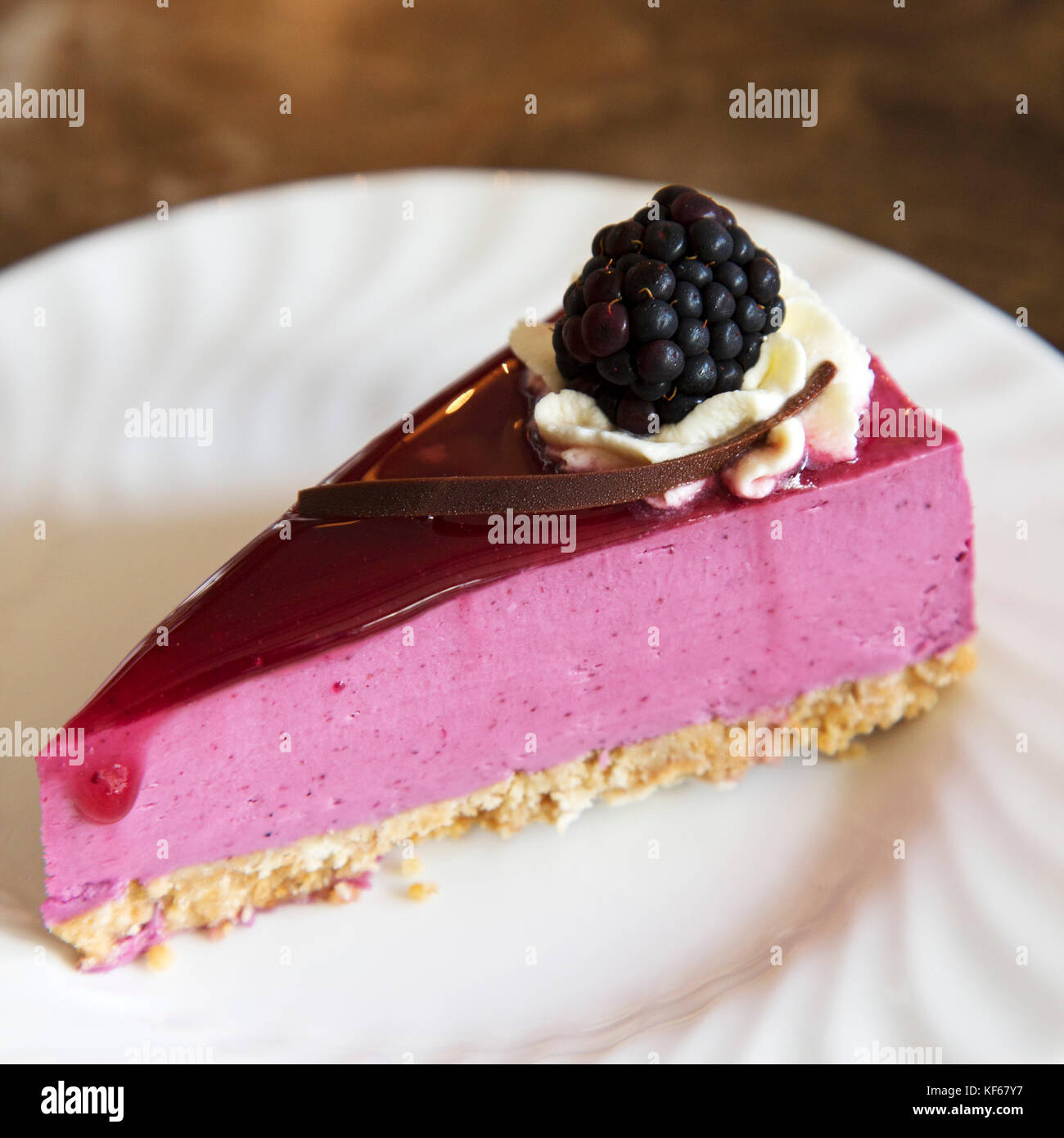 Une tranche de gâteau au fromage aux framboises. le gâteau est recouvert de crème glacée et une framboise. Banque D'Images