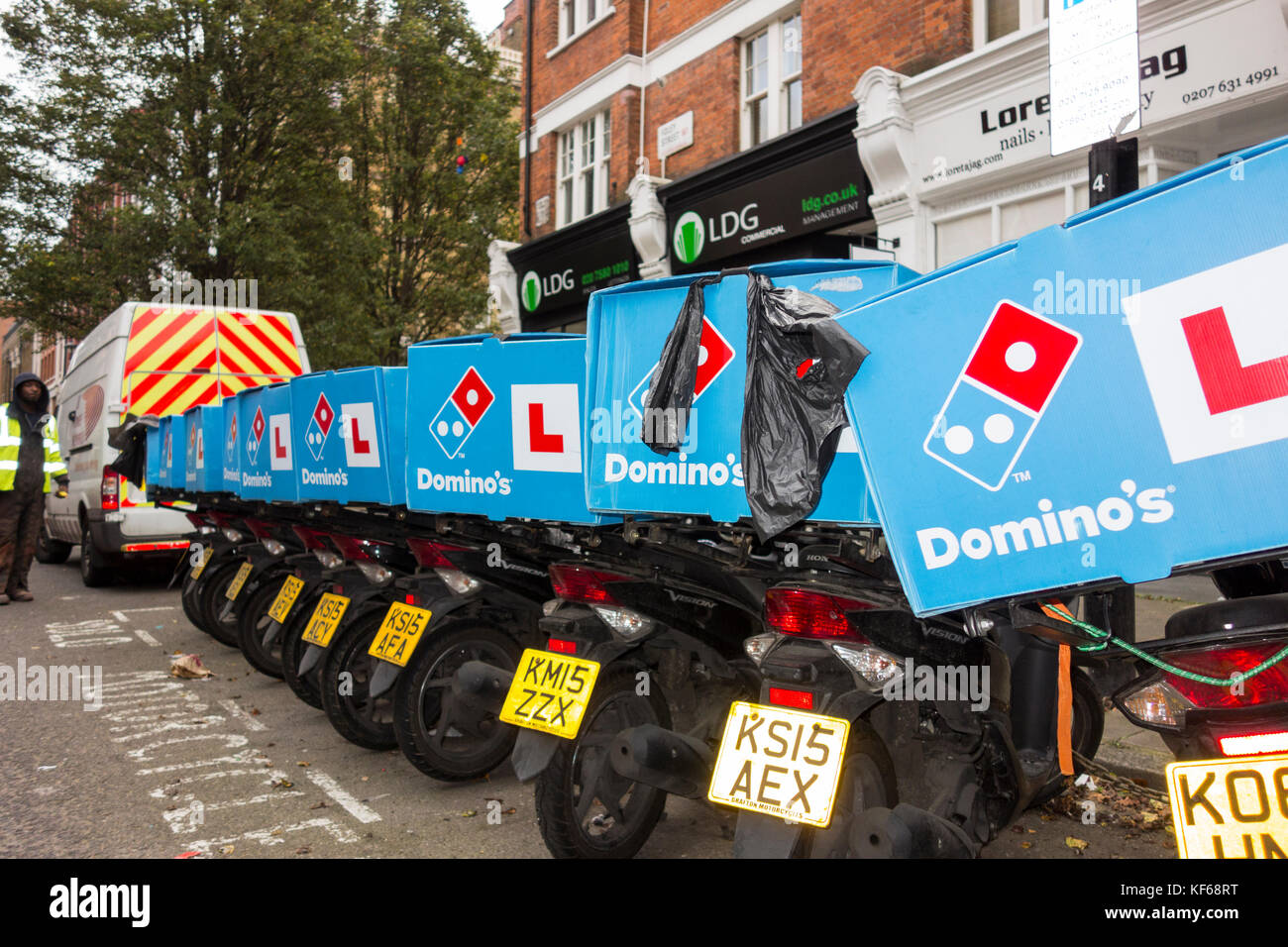 Une rangée de Domino's Pizza scooters livraison attendant dehors un Domino's restaurant dans le centre de Londres, UK Banque D'Images