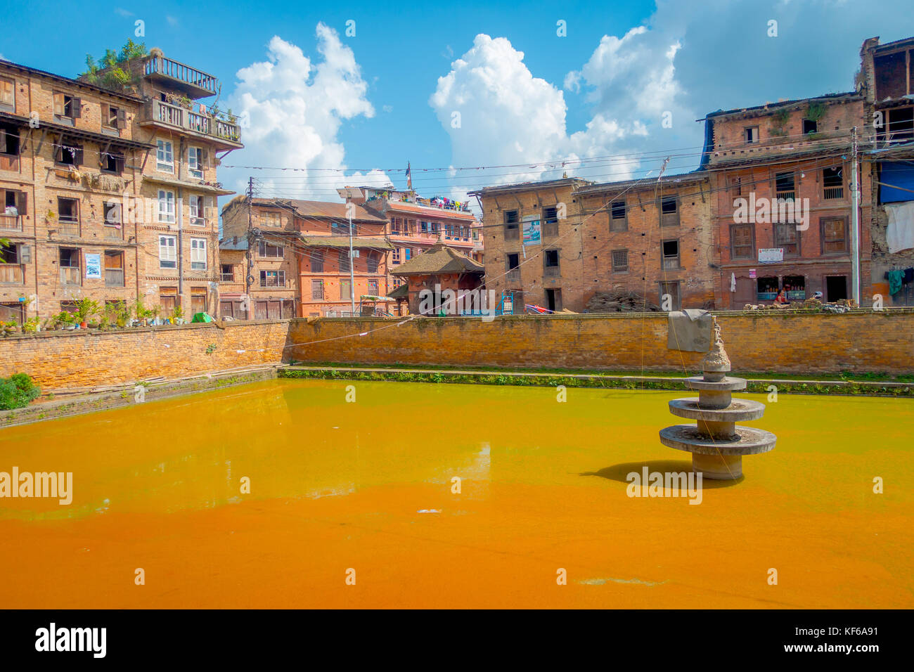 BHAKTAPUR, NÉPAL - 04 NOVEMBRE 2017 : gros plan de la scène urbaine traditionnelle avec un étang artificiel d'eau jaune dans la ville de Bhaktapur, Népal Banque D'Images BHAKTAPUR, NÉPAL - 04 NOVEMBRE 2017 : gros plan de la scène urbaine traditionnelle avec un étang artificiel d'eau jaune dans la ville de Bhaktapur, Népal Banque D'Images