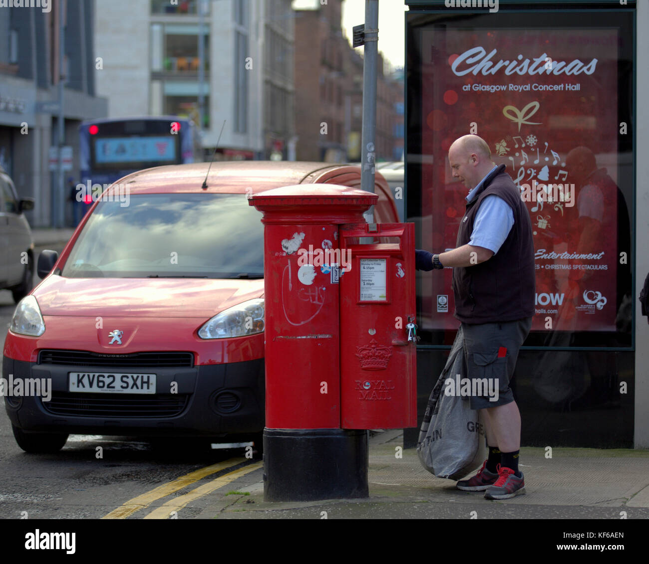 Royal Mail postman collectant des lettres rue rouge boîte postale van parlant à la cliente affiche de noël Banque D'Images