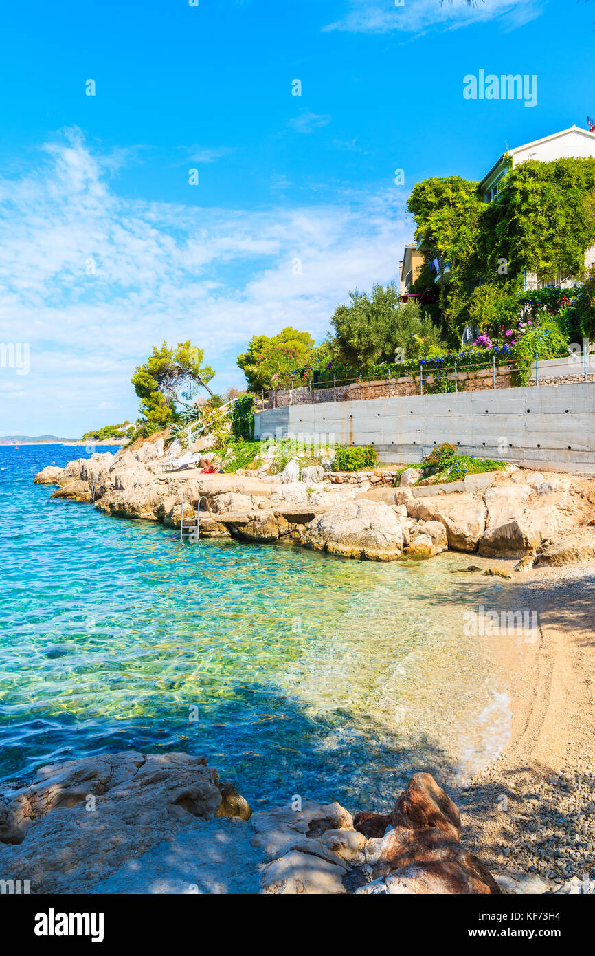 Petite plage de rochers et de la mer turquoise de l'eau dans la ville de Primosten, Croatie, Dalmatie Banque D'Images