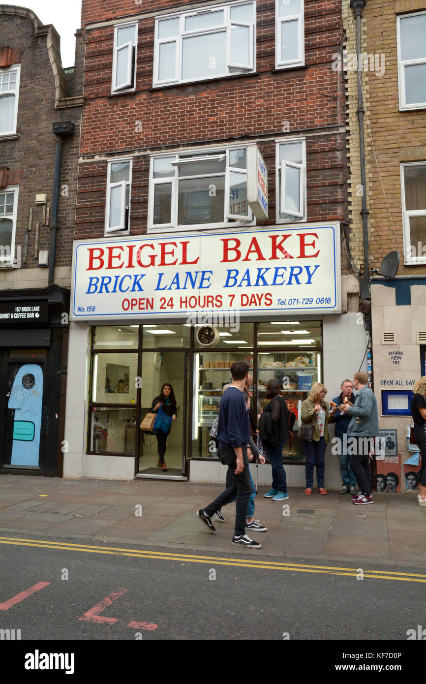 Les gens de manger des bagels à l'extérieur de la populaires Beigel Bake - une boutique ouverte 24h/24 dans Brick Lane London England Banque D'Images