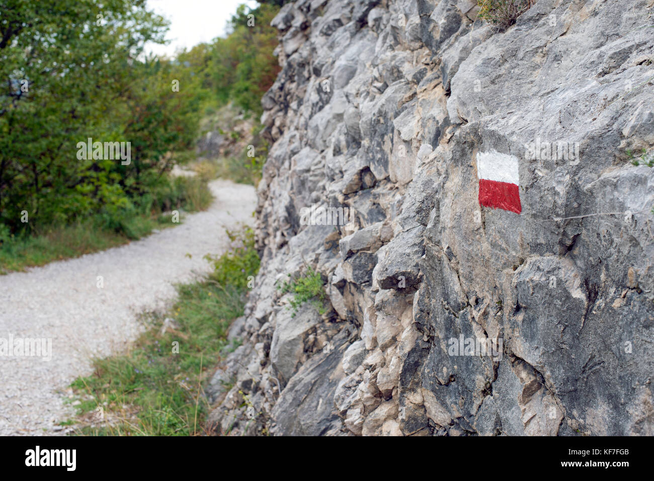 Rouge-blanc marque sur le rocher sur le sentier de montagne Banque D'Images